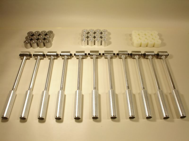 Precision tools, including t-handle wrenches and socket adapters, arranged on a white surface.