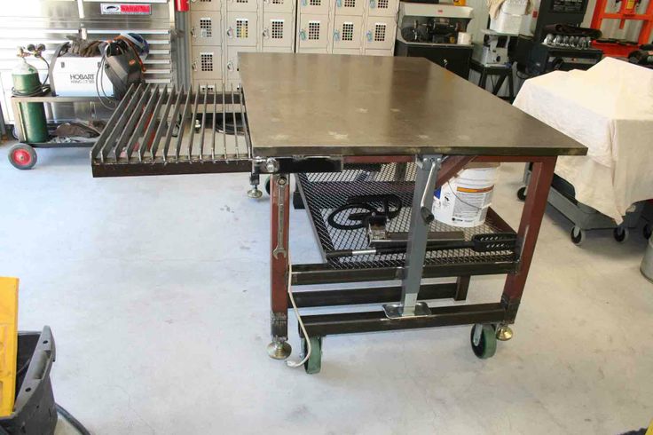 Steel welding table with pull-out plasma cutting rack.