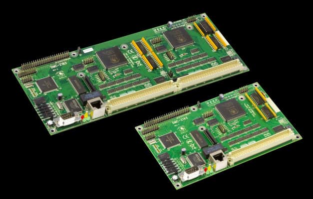 Two green circuit boards with yellow wires and black chips against a gray background.