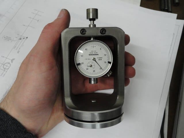 Dial indicator held by a hand.