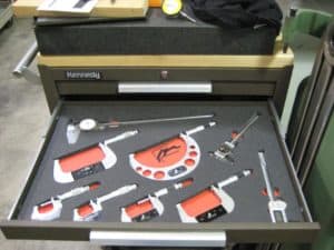 Neatly arranged toolbox containing wrenches, pliers, screwdrivers, and metalworking equipment.