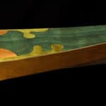 A close-up of a wooden object with a green and yellow design.