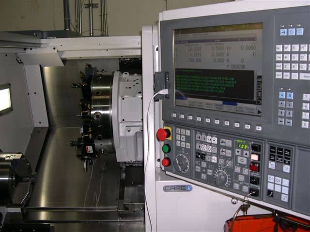 Computer numerical control (CNC) lathe with touchscreen interface and digital display.