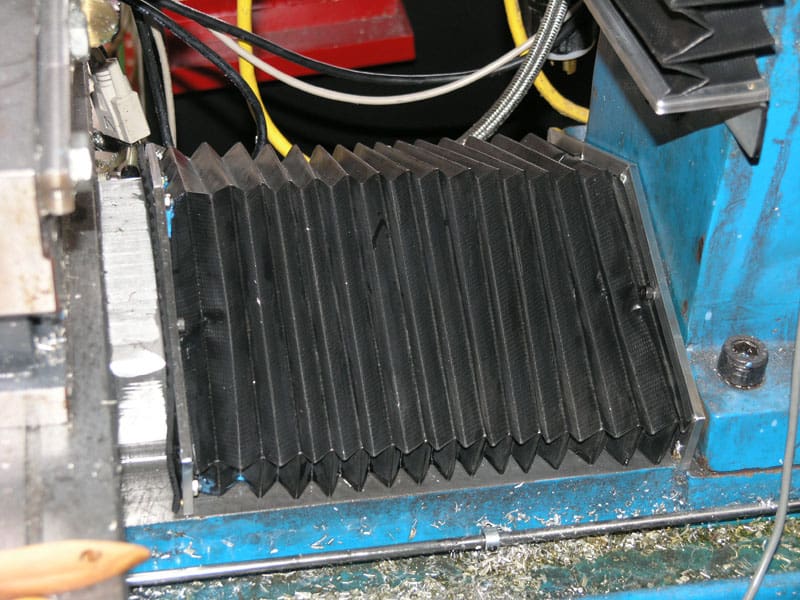 A blue machine with a central black, ridged component, likely used in metal fabrication or machining.