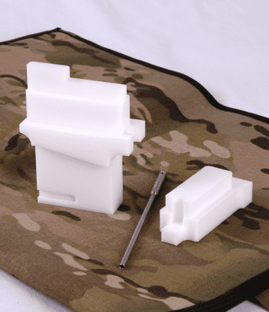 Camouflage-patterned cloth with rifle stock and metal tool.