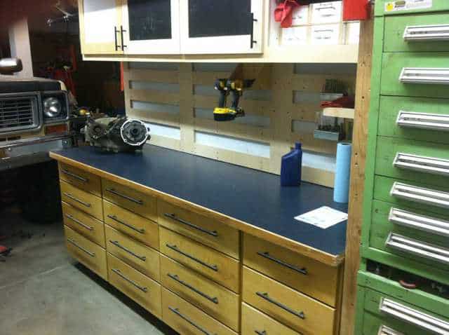 Well-organized workshop with wooden cabinets and drawers showcasing various tools and equipment.