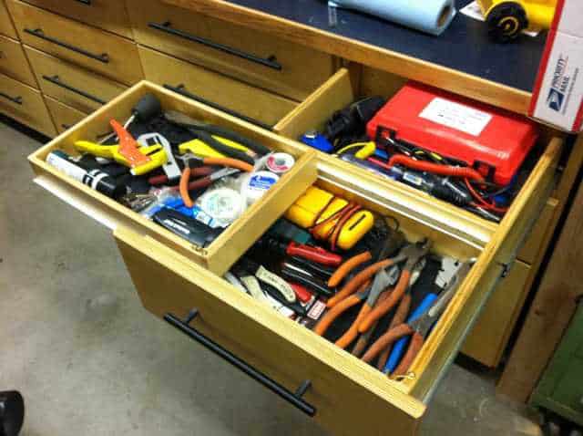 Wooden cabinet drawer filled with metalworking tools.