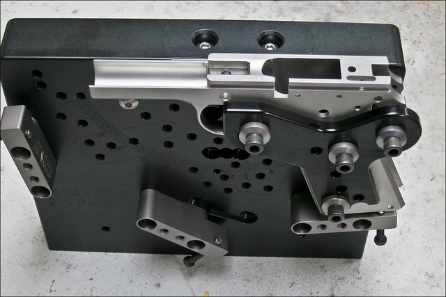 Black metal fixture with holes and silver metal attachment.