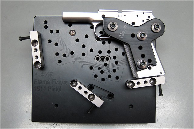 Black rectangular 1911 pistol flame fixture with attached metal components.
