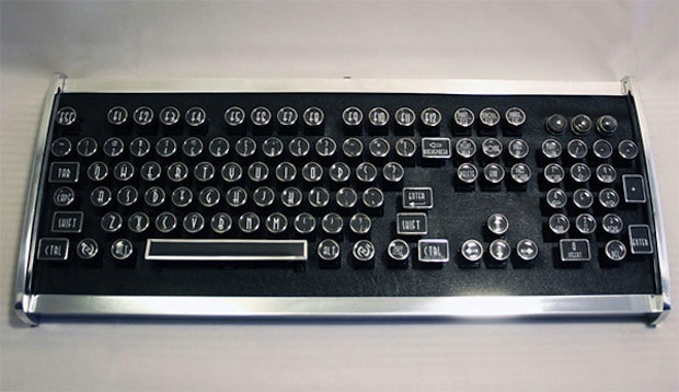 A vintage black keyboard with silver trim and circular keys.