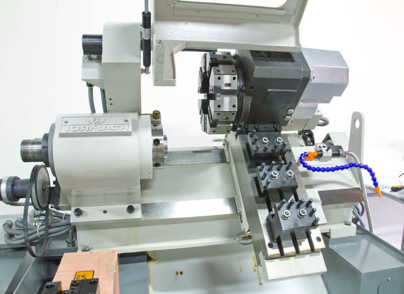 A lathe with various components and tools attached, primarily white with black and silver accents.