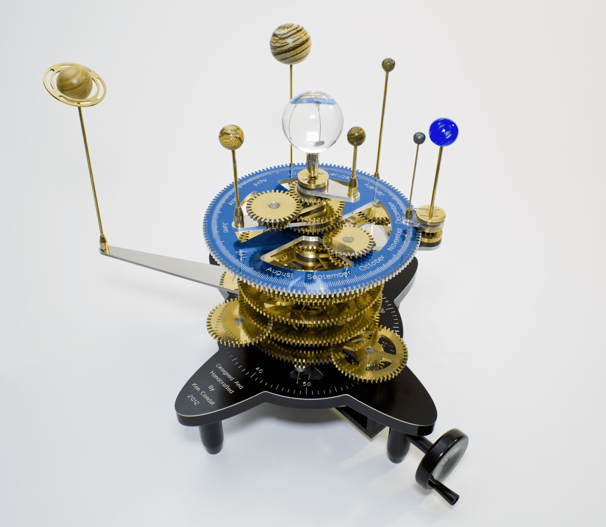 Ornate clockwork model of the solar system with blue dial, white text, and gold gears.