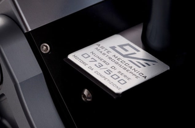 Metal plaque with text 'ARTE MECCANICA MASTROUSEPE 073/SDD NUMERO DI SERIE NOTO DA COMPETIZIONE'.