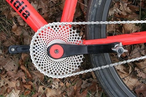 Bicycle chainring sprocket with 'Drillium' text on side, set against brown foliage.
