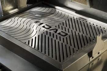 Stainless steel grill with custom 'DAD' logo and parallel lines etched into its surface.