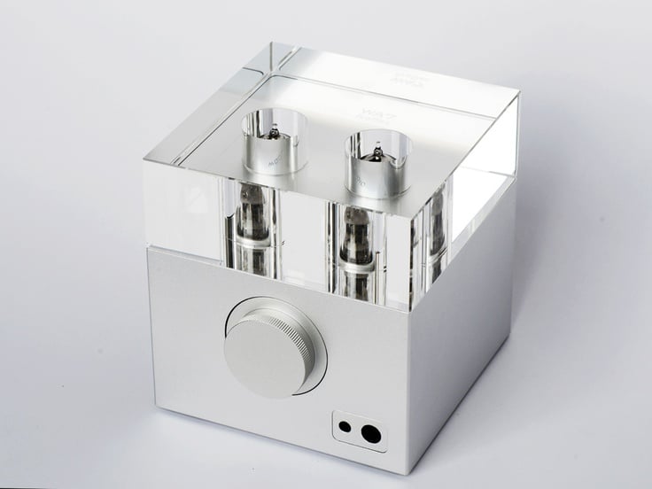 A sleek, modern silver audio component with two glass tubes and a circular knob.