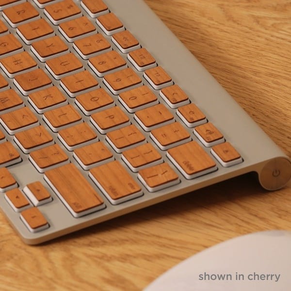 Wooden keyboard with silver frame and brown wooden keys on a light wood grain background.