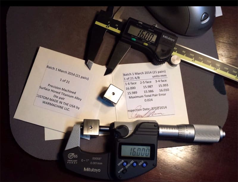 Precision measurement tools on a dark wooden desk with Mitutoyo calipers.