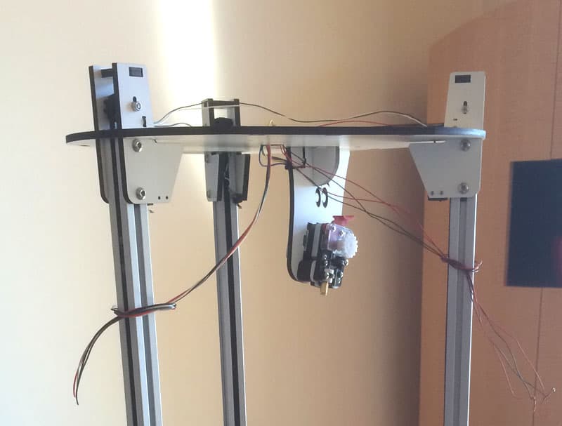 White metal CNC 3D printer extruder with black plastic component and wires.