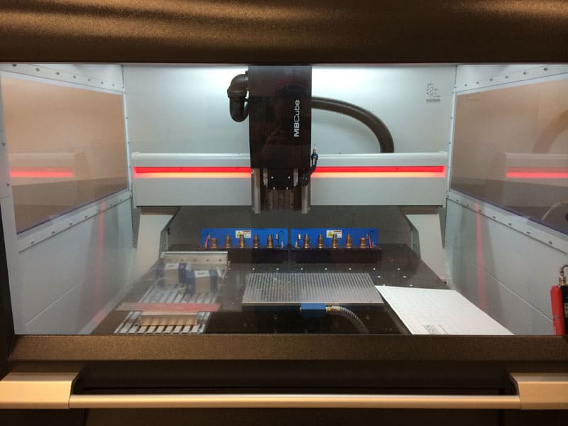 A black and white CNC machine with red lights and sleek design.