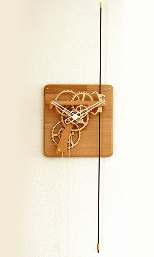 Distinctive wooden wall clock with gear mechanism on its face.
