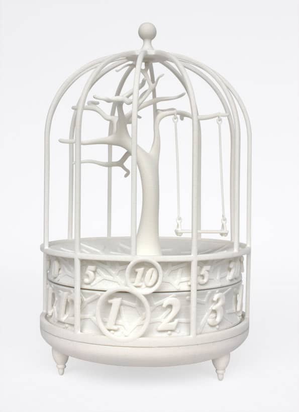 White birdcage with ornate design, tree in center, numbers on sides.