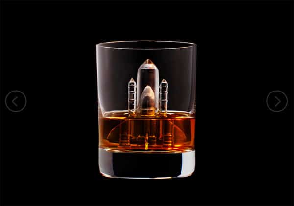 Amber-colored liquid in a clear tumbler on a black background.