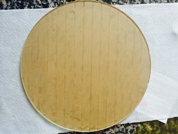Circular wooden template with vertical lines.