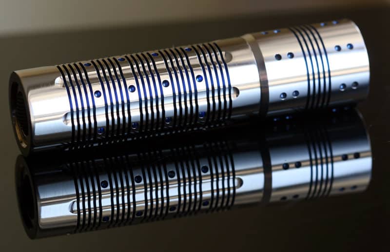 Cylindrical metal object with parallel grooves and small blue markings.