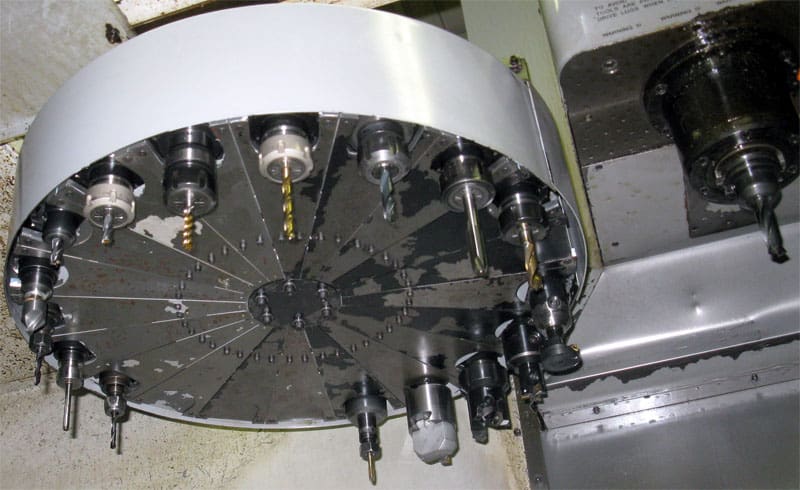 Large metal component with multiple drill bits arranged around its edge.