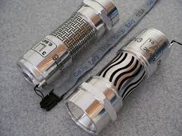 Silver finished metal cylinders with woven and wavy designs.