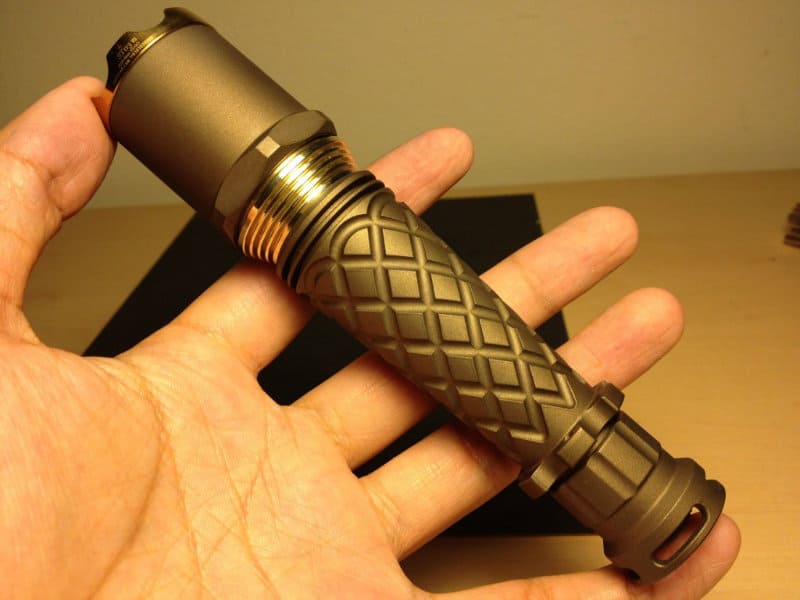 A hand holding a tool with a diamond-patterned grip.