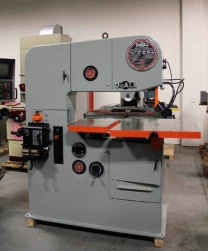 Large industrial DoALL Bandsaw with gray metal body, black handlebars and orange table.