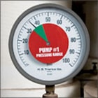 Round gauge with red center, white face, and green triangle pointing to "1".