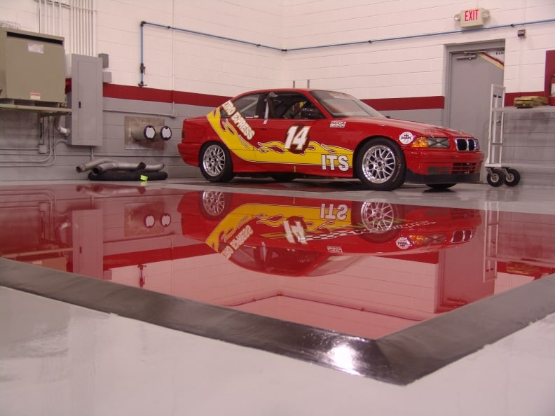 A shiny red car with yellow accents in a garage or workshop setting.