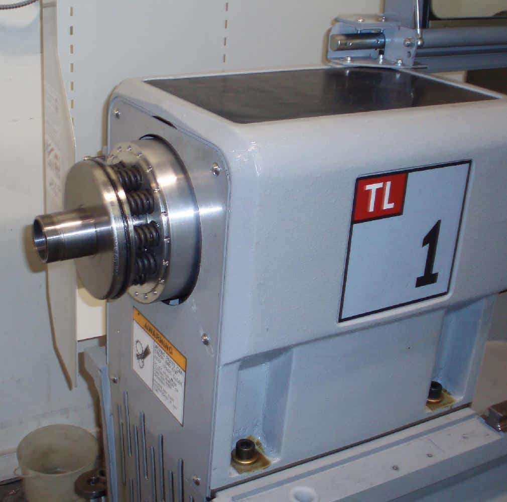 Large machine with silver cylindrical component, TL logo and gray background.