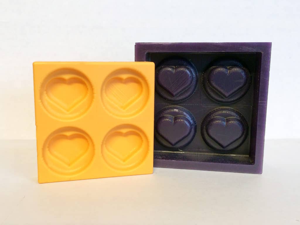 Square chocolate mold with four heart-shaped cavities.