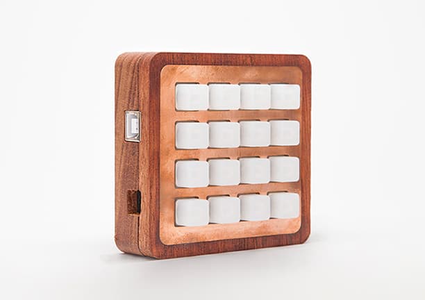 Compact wooden machine enclosure with white buttons and metal latch.
