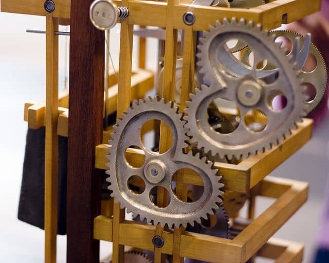 Intricate mechanical gears in silver and wood tones.