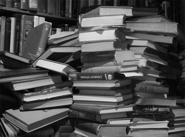 A stack of books in disarray on a desk or table.