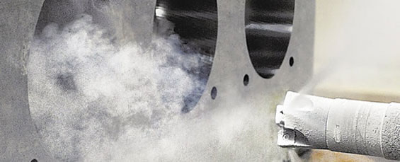 Metal surface with holes and cloudy white substance.