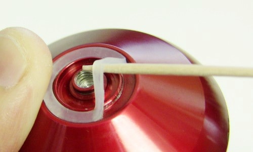 A close-up of a red yo-yo on a white string.