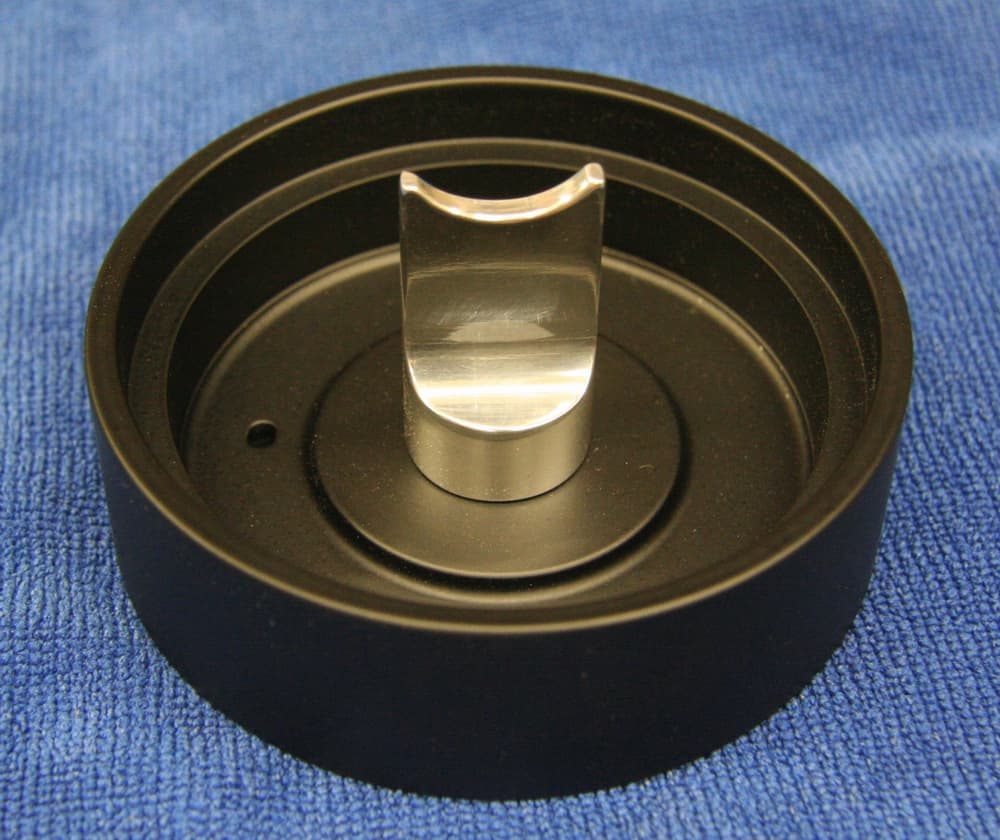 Circular object with metallic center on blue background.