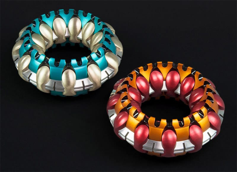 Two torus-shaped objects with colorful rounded sections against a black background.