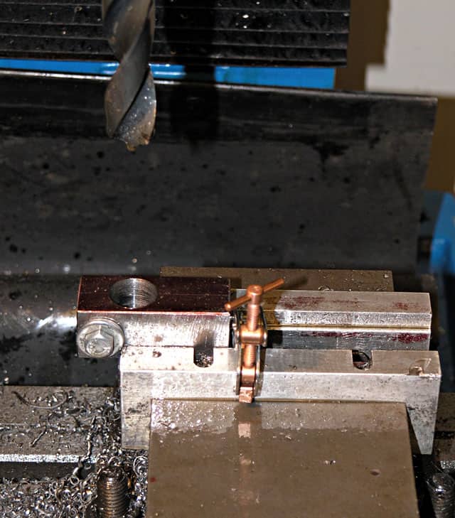 Milling machine vise clamped with metal block.