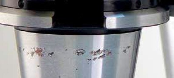 Close-up of worn metal object with scratches and corrosion.