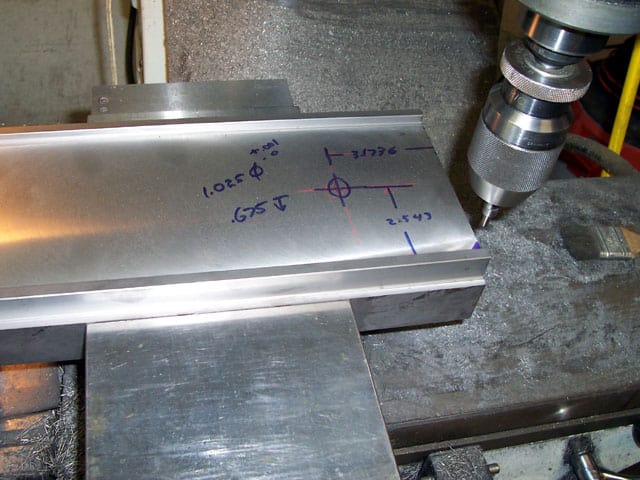 Metal part with blue-ink measurements.