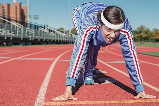 Person in athletic attire at a running track.