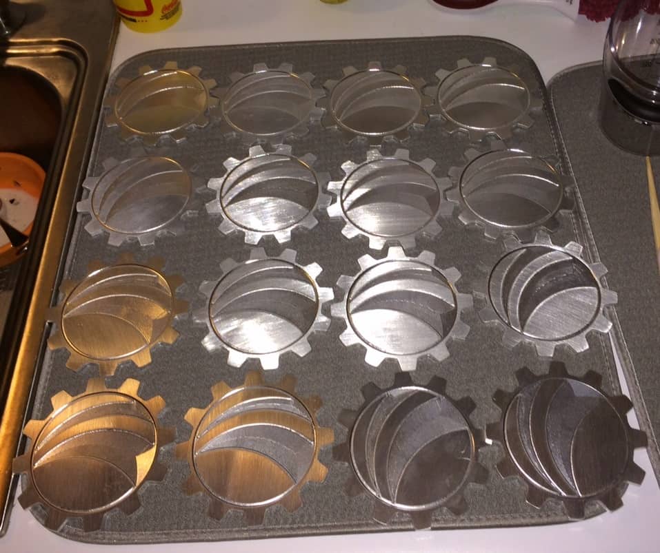 Metal cupcake pan with interlocking gear design.