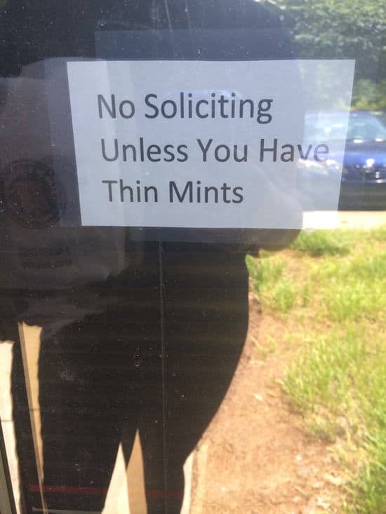 Sign with black text reading "No Soliciting Unless You Have Thin Mints" against a transparent background.